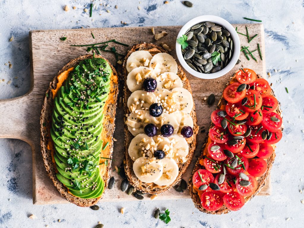 Avocado Toast, Banana Toast, & Tomato Toast on a wooden board