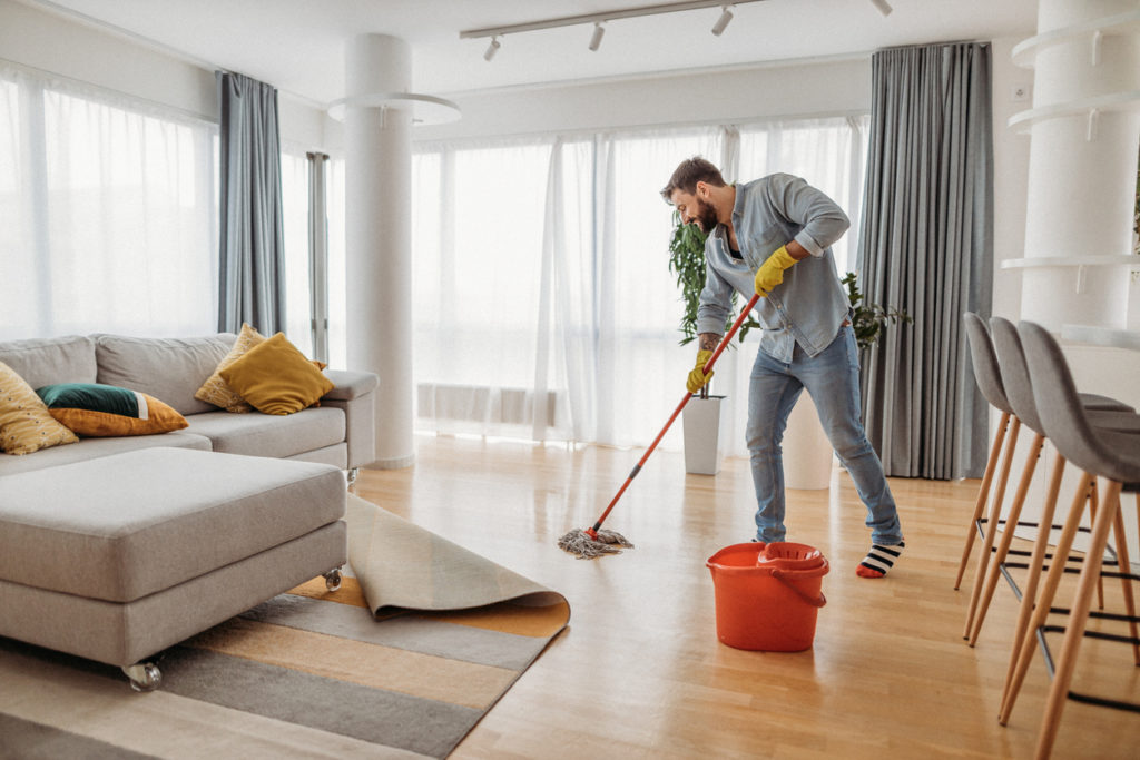 Young man cleaning his apartment