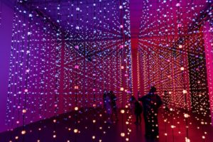 interactive light orb museum room with visitors interacting with hanging orbs